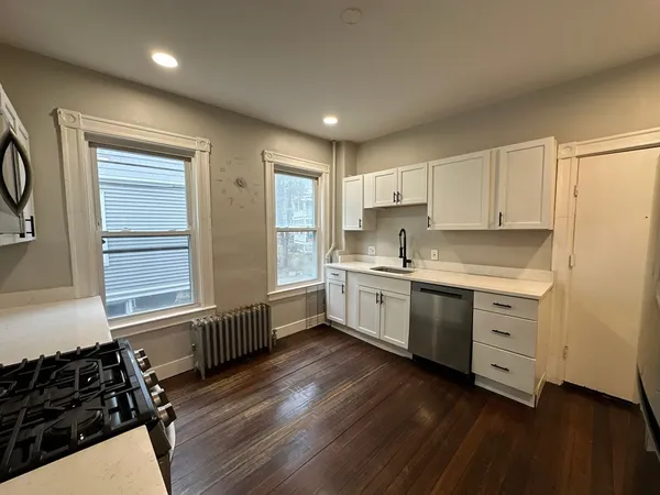 a kitchen with granite countertop white cabinets and white appliances