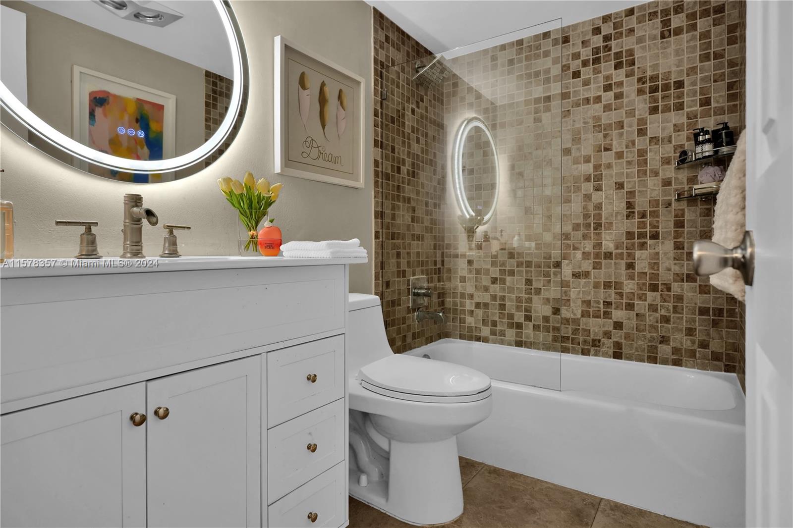 950 Hillcrest Drive, Unit 114 Hollywood, FL 33021 - Photo 13 of 24 a bathroom with a sink a mirror a toilet and a bathtub