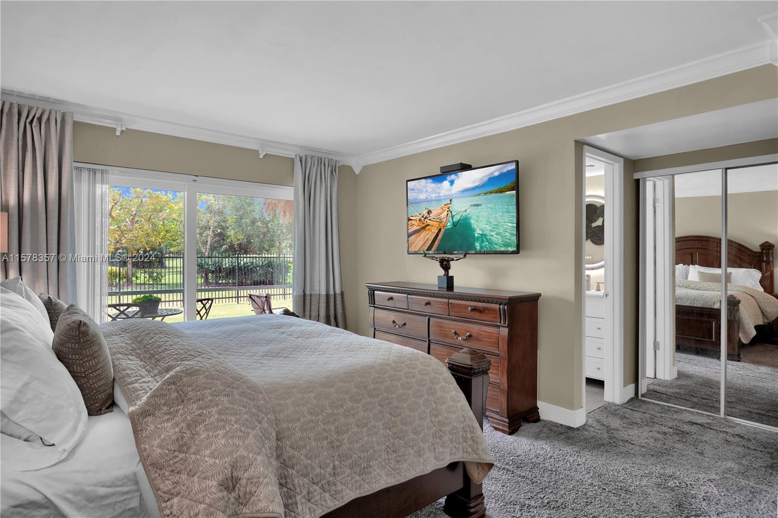 950 Hillcrest Drive, Unit 114 Hollywood, FL 33021 - Photo 14 of 24 a bedroom with a bed and a flat screen tv