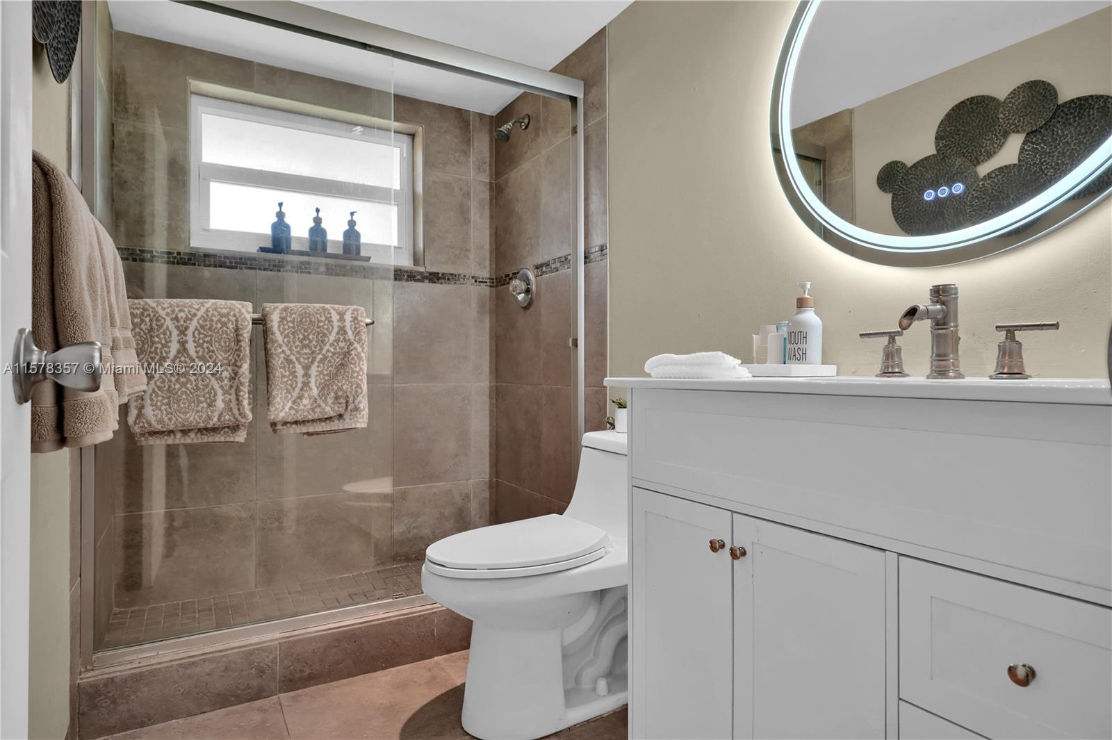 950 Hillcrest Drive, Unit 114 Hollywood, FL 33021 - Photo 16 of 24 a bathroom with a toilet a sink and a mirror