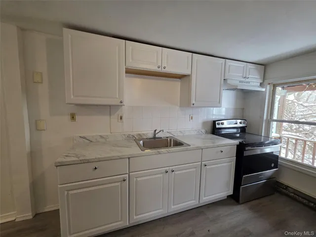 a kitchen with a sink dishwasher stove and cabinets