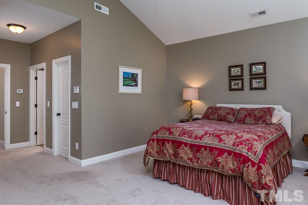 654 Democracy Street Raleigh, NC 27603 - Photo 11 of 24 a bedroom with a bed and a night stand