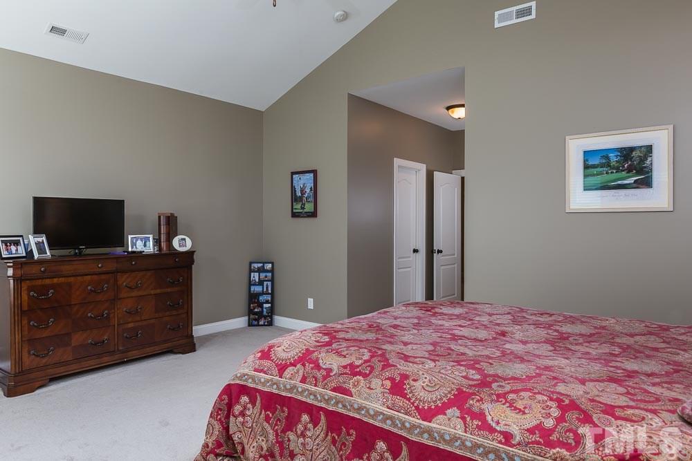 654 Democracy Street Raleigh, NC 27603 - Photo 12 of 24 a bedroom with a bed and a dresser