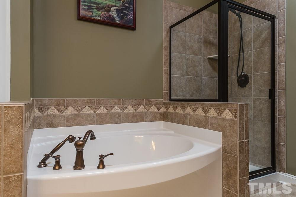 654 Democracy Street Raleigh, NC 27603 - Photo 13 of 24 a bathroom with a bathtub and shower