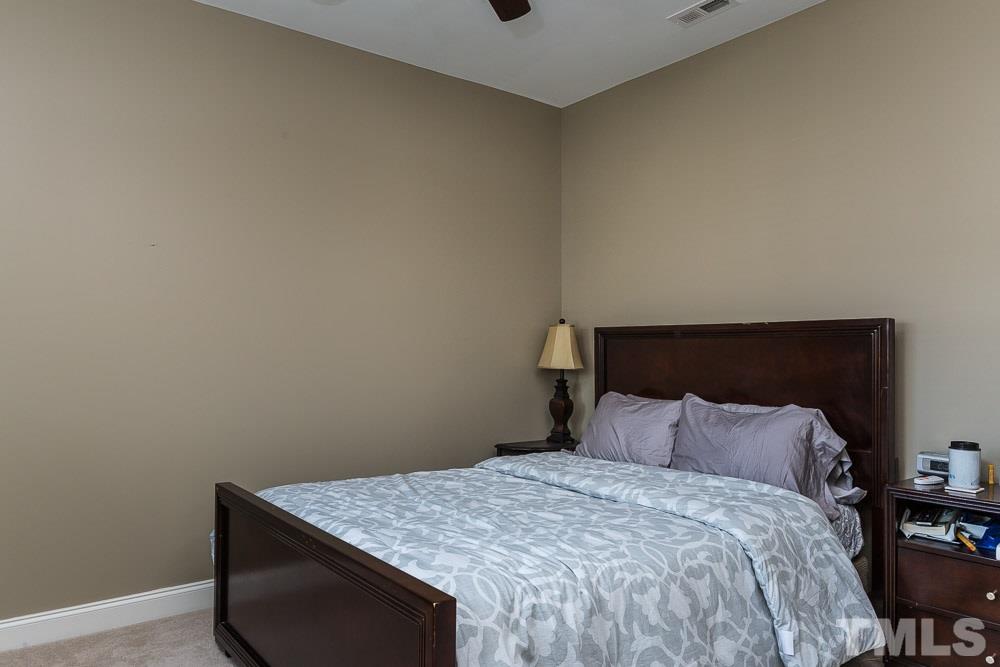 654 Democracy Street Raleigh, NC 27603 - Photo 15 of 24 a bedroom with a bed and a chair