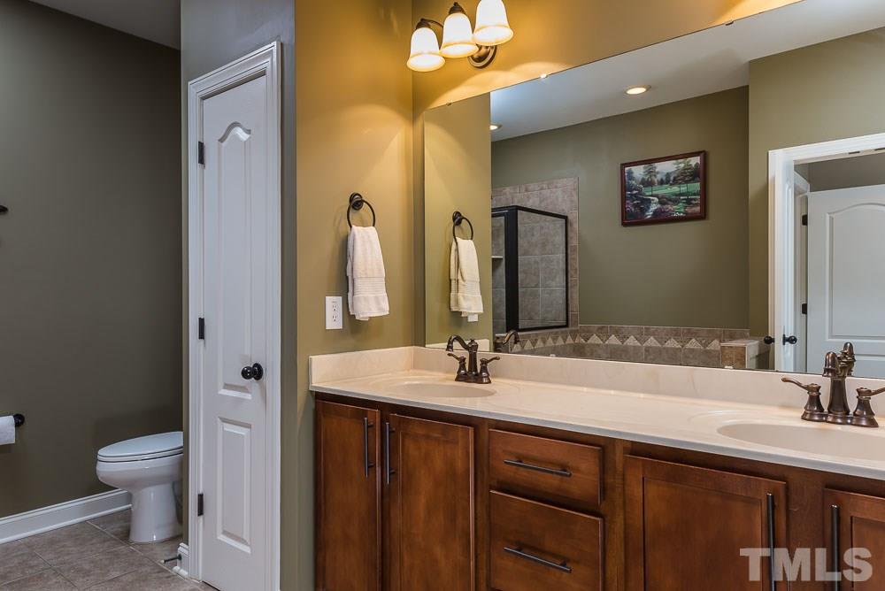654 Democracy Street Raleigh, NC 27603 - Photo 16 of 24 a bathroom with a double vanity sink and a mirror