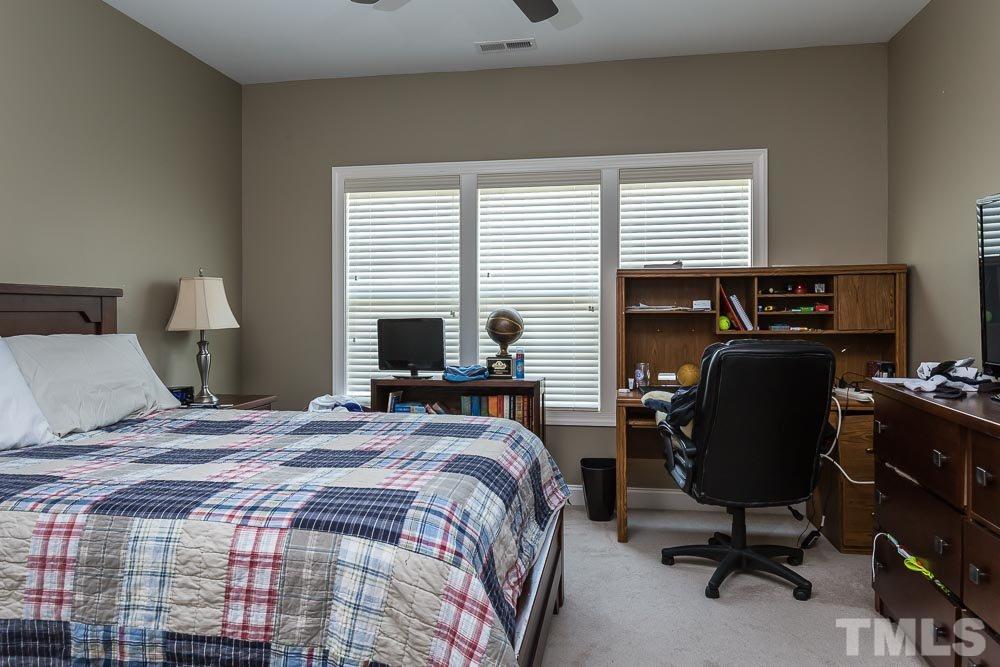 654 Democracy Street Raleigh, NC 27603 - Photo 17 of 24 a bedroom with a bed a computer on the desk and a chair