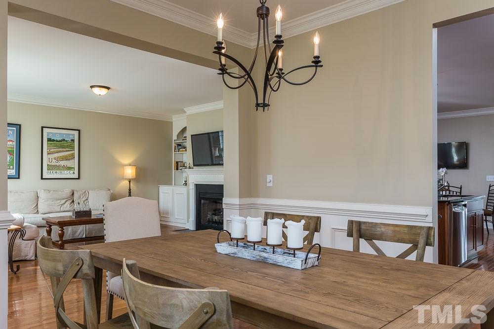 654 Democracy Street Raleigh, NC 27603 - Photo 6 of 24 a dining room with furniture a chandelier and wooden floor