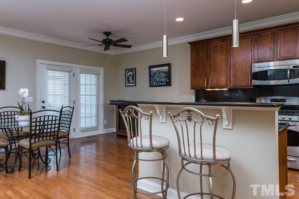 654 Democracy Street Raleigh, NC 27603 - Photo 8 of 24 a kitchen with stainless steel appliances granite countertop a dining table chairs and granite counter tops