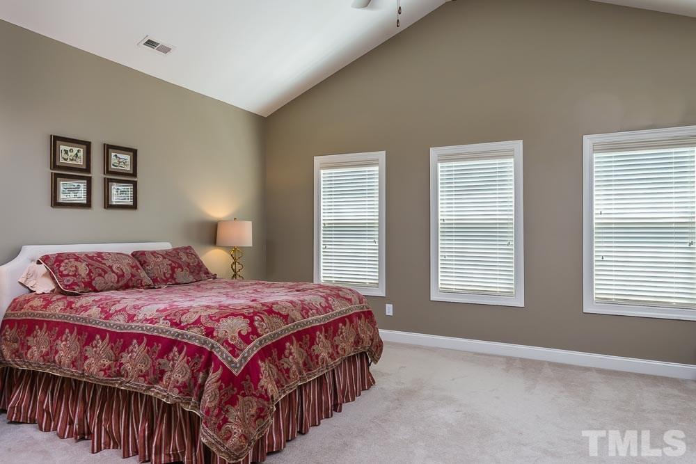 654 Democracy Street Raleigh, NC 27603 - Photo 10 of 24 a bedroom with a bed a window and painting on the wall
