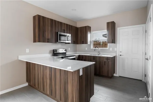 a kitchen with a sink and a stove top oven with wooden floor