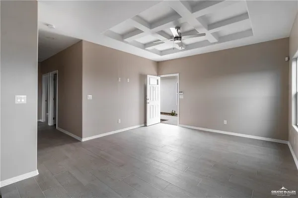 an empty room with a chandelier fan and glass door