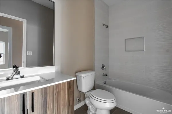 a bathroom with a granite countertop toilet a sink and a mirror