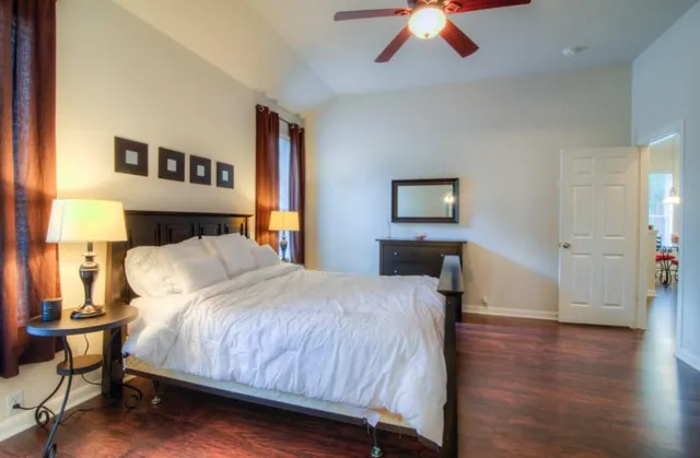 a bedroom with a large bed and a chandelier