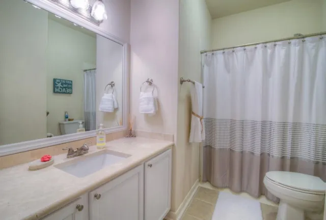a bathroom with a sink a toilet and shower curtain