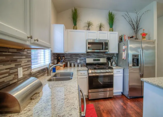 a kitchen with granite countertop a stove and a microwave oven