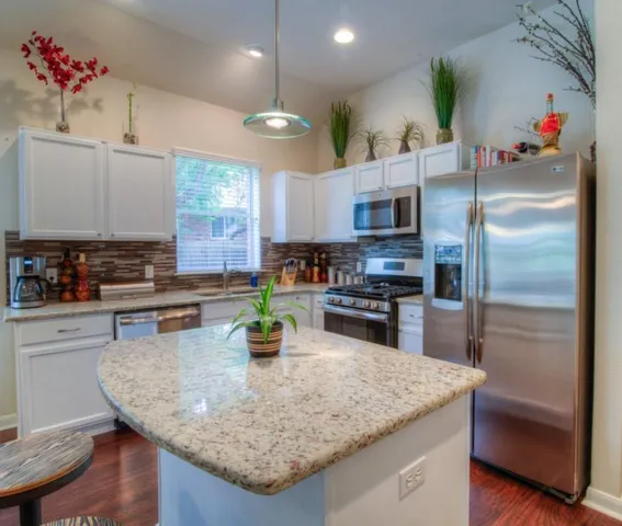 a kitchen with stainless steel appliances granite countertop a sink refrigerator and microwave