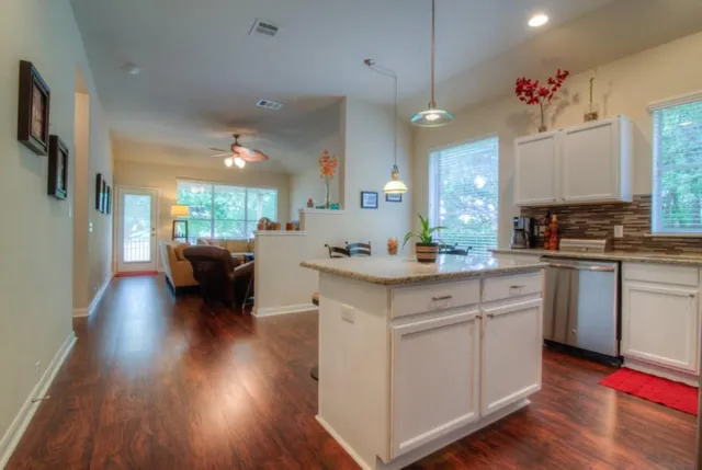 a kitchen with a sink cabinets and wooden floor