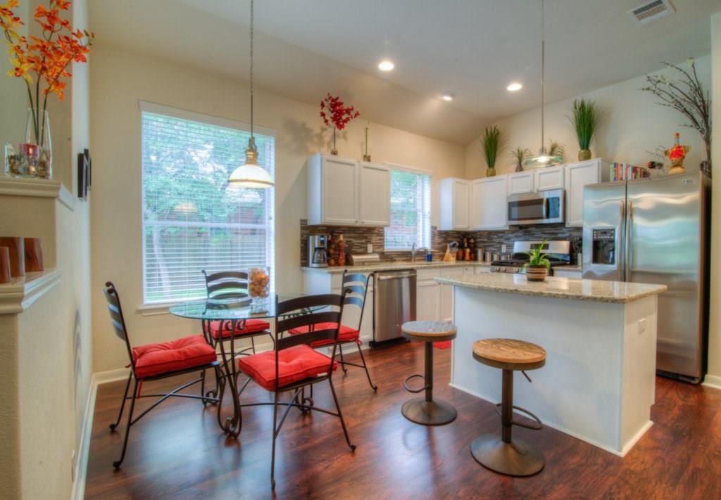 3454 Shiraz Loop Round Rock, TX 78665 - Photo 6 of 23 a living room with stainless steel appliances kitchen island a table chairs and a refrigerator