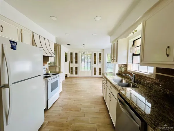 a kitchen with stainless steel appliances granite countertop a refrigerator a stove and a sink