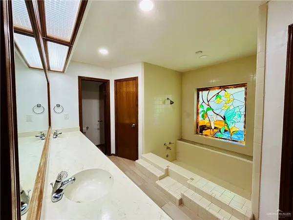 a spacious bathroom with a shower and a sink