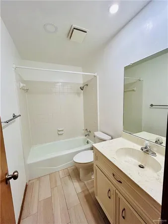 a bathroom with a granite countertop sink a toilet a mirror and shower