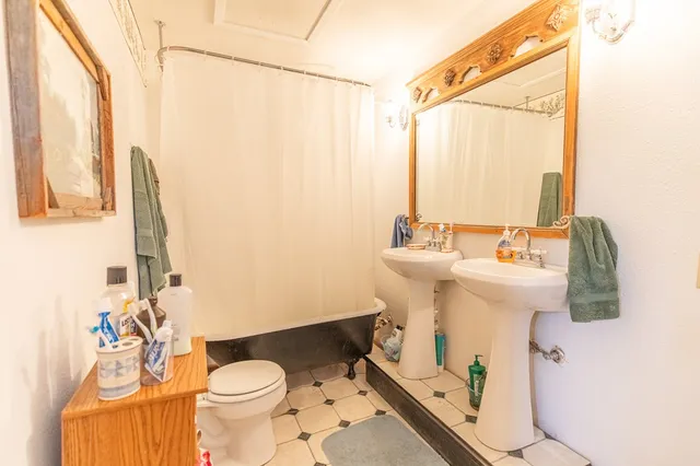 a bathroom with a sink and mirror with toilet