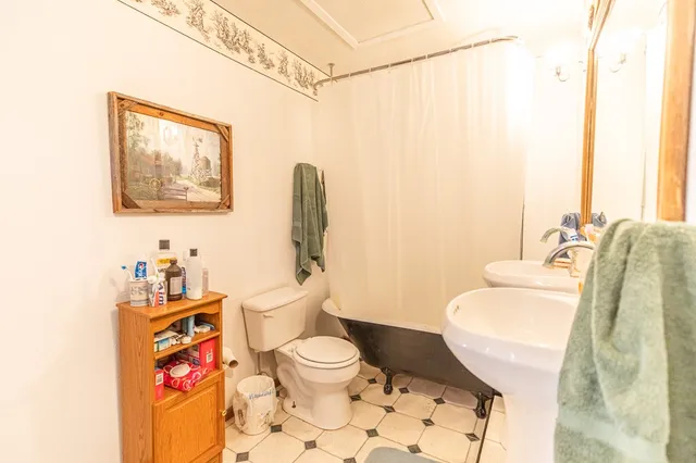 a bathroom with a toilet sink and mirror