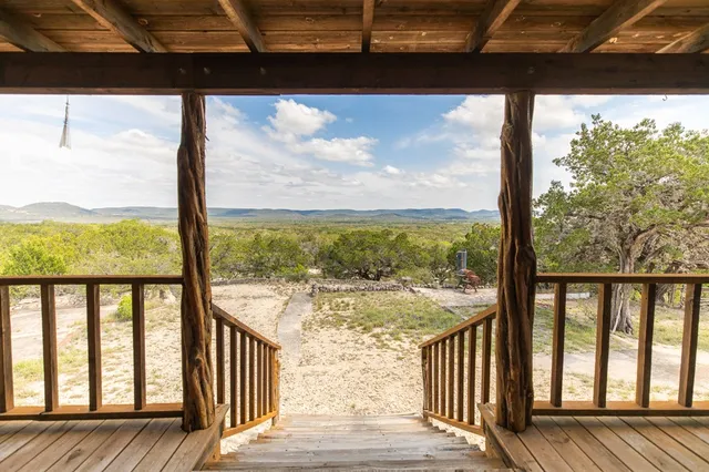 a view of a wooden balcony with a yard