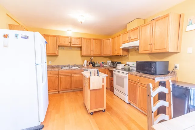 a kitchen with stainless steel appliances granite countertop a stove a sink and a refrigerator