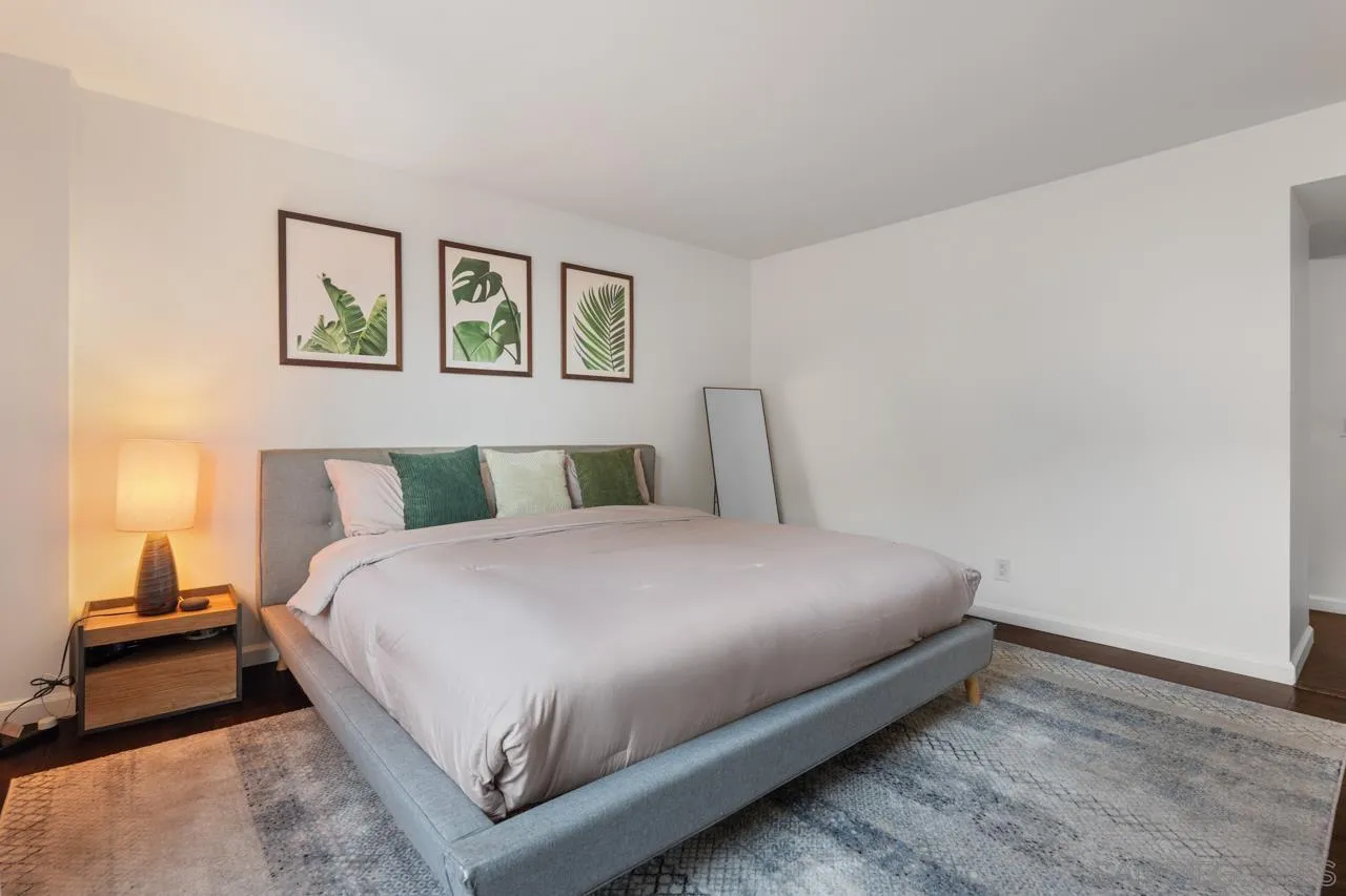 3635 7th Avenue, Unit 2D San Diego, CA 92103 - Photo 30 of 68 a large bed sitting in a bedroom next to a lamp