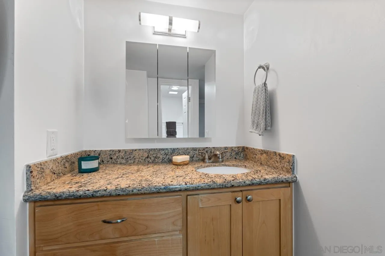 3635 7th Avenue, Unit 2D San Diego, CA 92103 - Photo 42 of 68 a bathroom with a granite countertop sink and a mirror