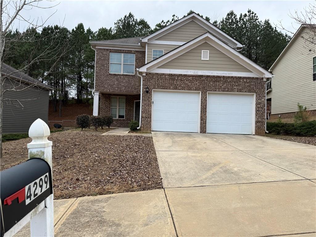 4299 Traipse Path Ellenwood, GA 30294 - Photo 1 of 12 a front view of a house with a yard and garage