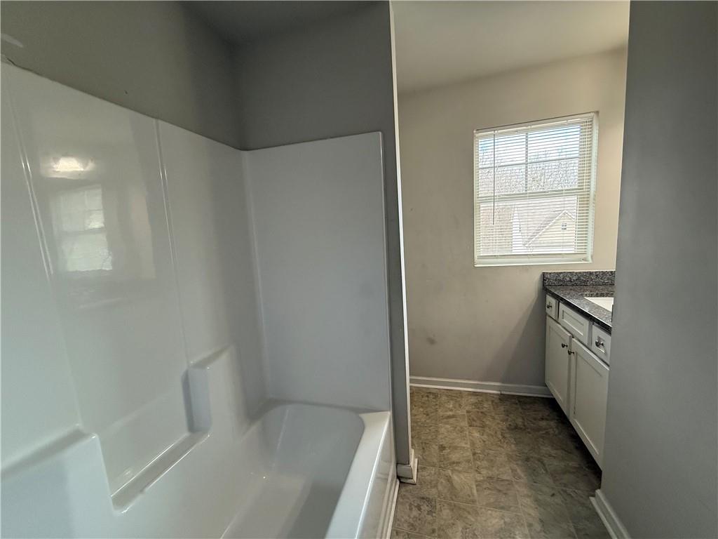 4299 Traipse Path Ellenwood, GA 30294 - Photo 12 of 12 a bathroom with a bathtub sink and window