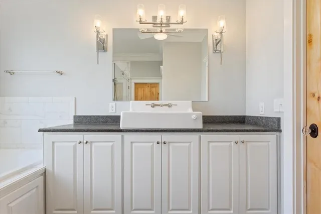 a kitchen with granite countertop a sink and a white cabinets