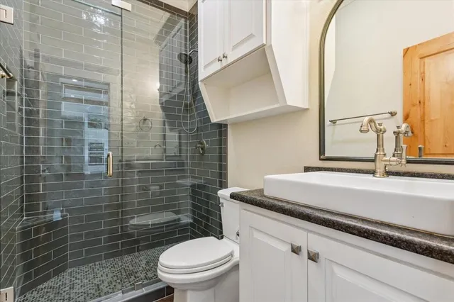 a bathroom with a granite countertop toilet sink and mirror