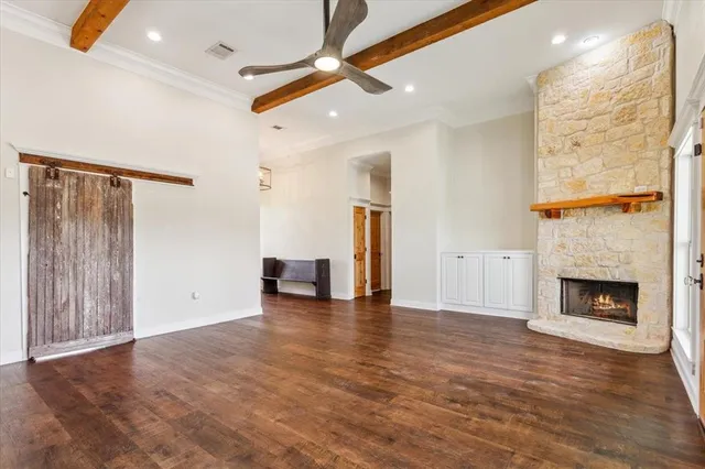 a view of an empty room with wooden floor fireplace and a window