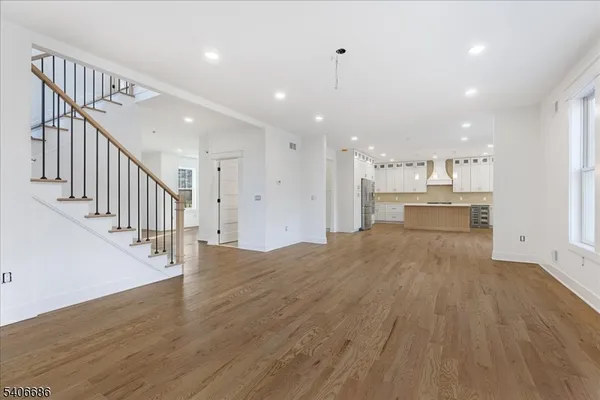an empty room with wooden floor fireplace and windows