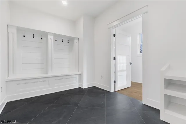 a view of a hallway with wooden floor and a cabinet