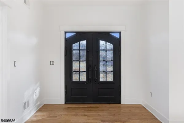 a large kitchen with stainless steel appliances granite countertop a stove a refrigerator a sink and a oven with wooden floors