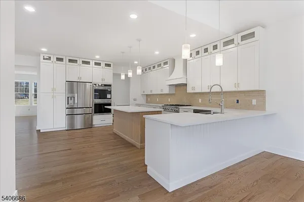 a large kitchen with a lot of counter space and wooden floor