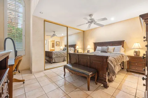 a bedroom with a bed a couch and a chandelier