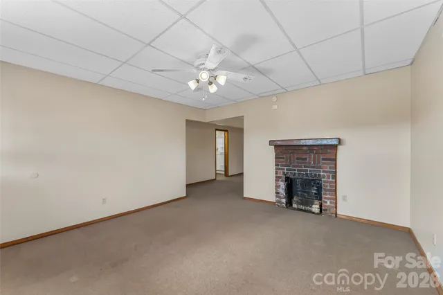 an empty room with fireplace and fan