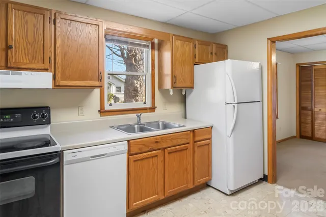 a kitchen with a refrigerator sink stove and cabinets