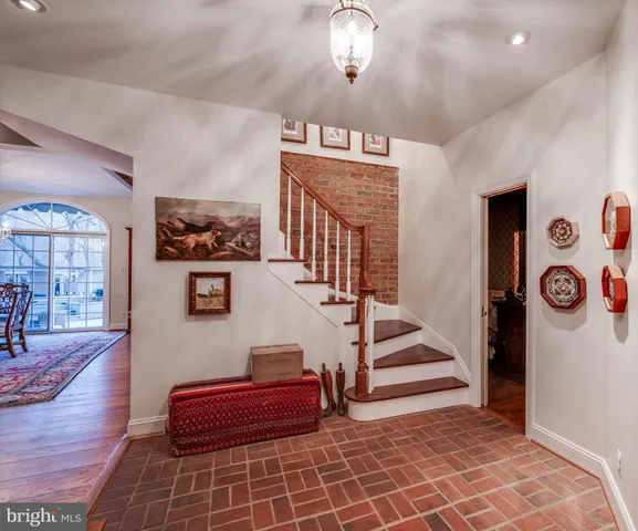 a living room with furniture a fireplace and a chandelier