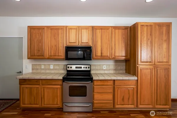 a kitchen with stainless steel appliances granite countertop a stove a sink and a microwave