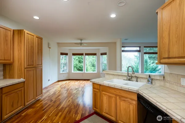a kitchen with stainless steel appliances granite countertop a sink a stove and a refrigerator