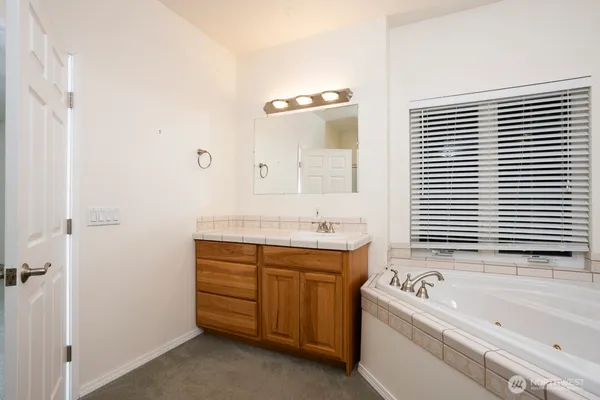 a bathroom with a tub sink and mirror
