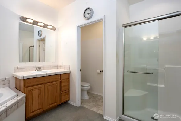 a bathroom with a granite countertop sink toilet and shower