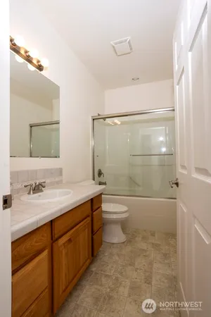 a bathroom with a granite countertop sink toilet and shower